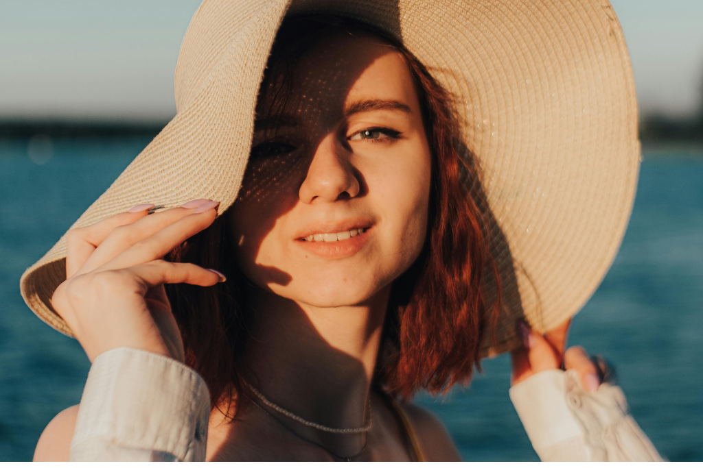 Une femme porte un chapeau pour se protéger de la lumière mais également pour cacher une partie de son grand front