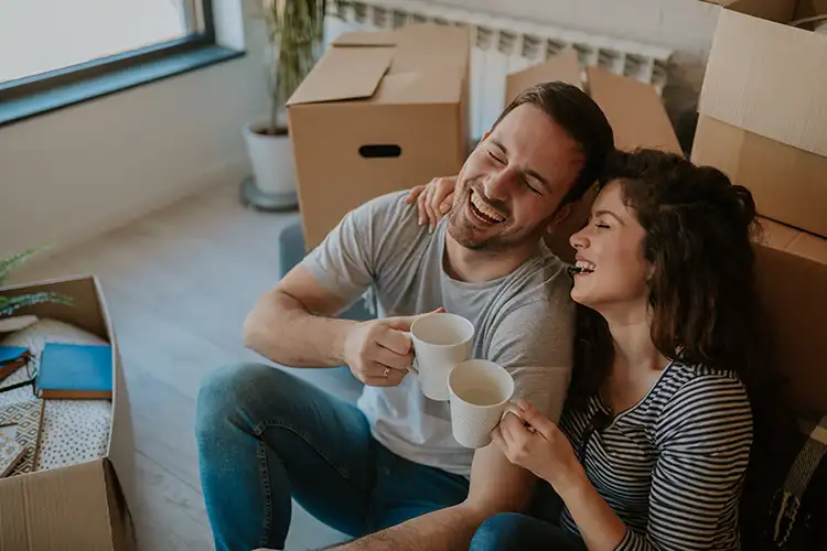 Un homme et une femme heureux en couple assis, riant et en train de partager un café