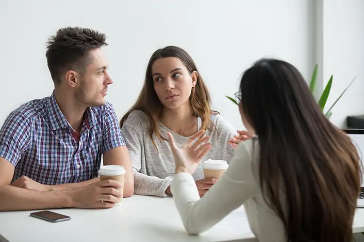 Un couple homme et femme regardant avec doute et incertitude en buvant un café