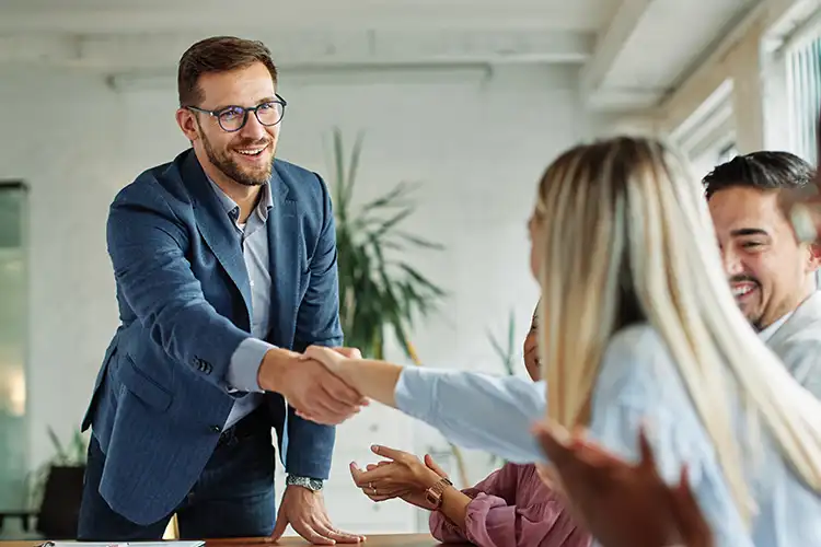 Un homme confiant et souriant lors d’une poignée de main