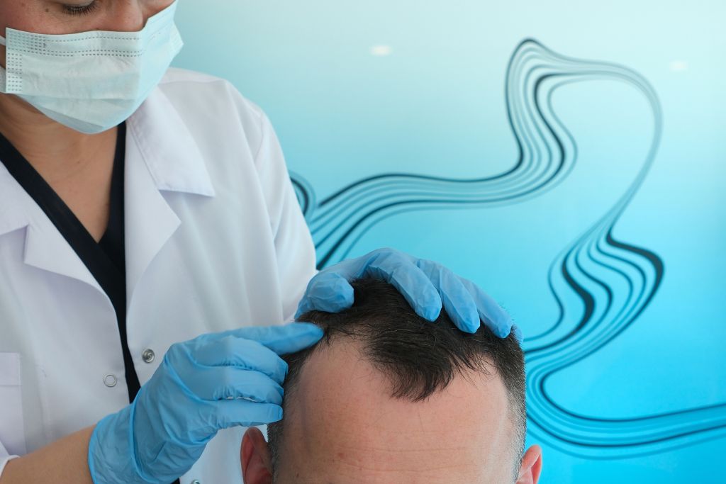 Un médecin de la clinique fait une consultation avec un patient ayant une perte de cheveux au niveau des golfes frontaux