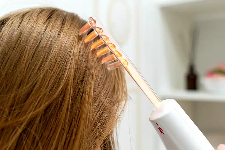 Application d’un peigne électrique sur les cheveux