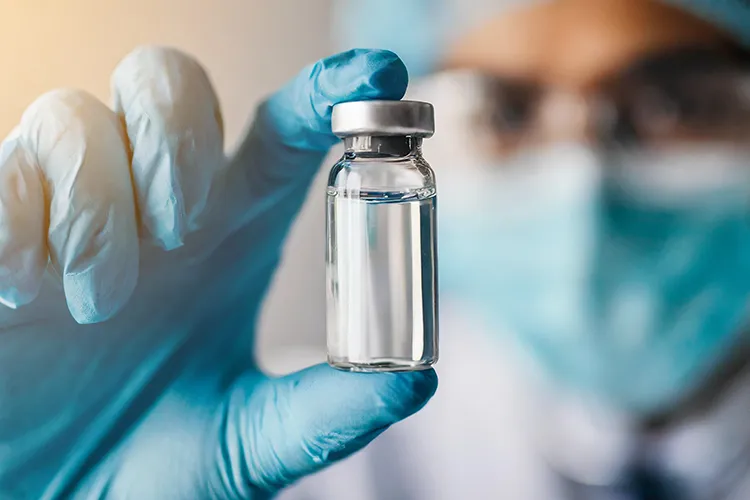 Un chercheur tient une ampoule contenant un liquide dans un laboratoire.