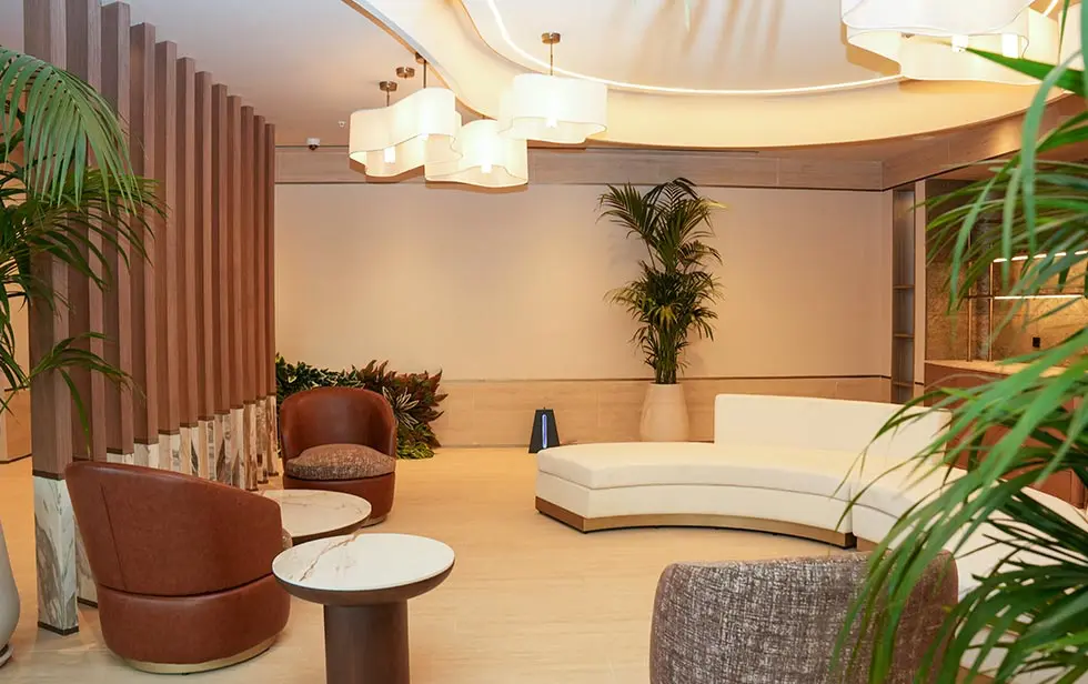 Espace salon moderne à l'hôtel Elitoria avec sièges, plantes et éclairage