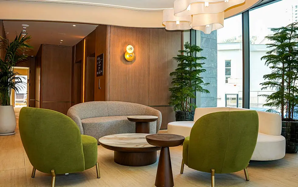 Coin salon moderne à l'hôtel Elitoria avec mobilier, fenêtres et éclairage