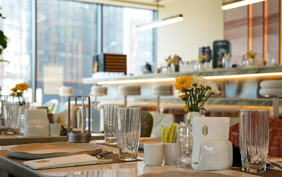 Décoration de table à l’Elitoria Hotel avec fleurs blanches et jaunes au premier plan