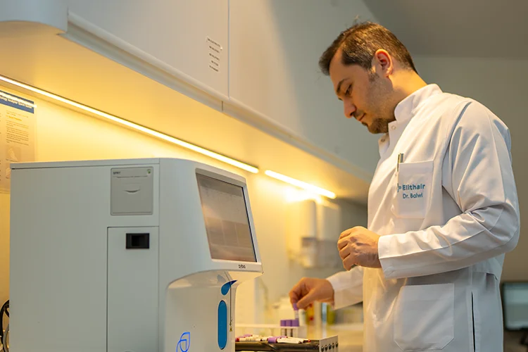 Laboratoire moderne Elithair où des études scientifiques sont réalisées sous la supervision du Dr Balwi, avec des équipements médicaux et des analyses capillaires.