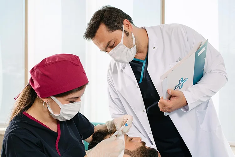 Équipe médicale spécialisée en greffe capillaire entourant le Dr Abdulaziz Balwi lors d’une intervention