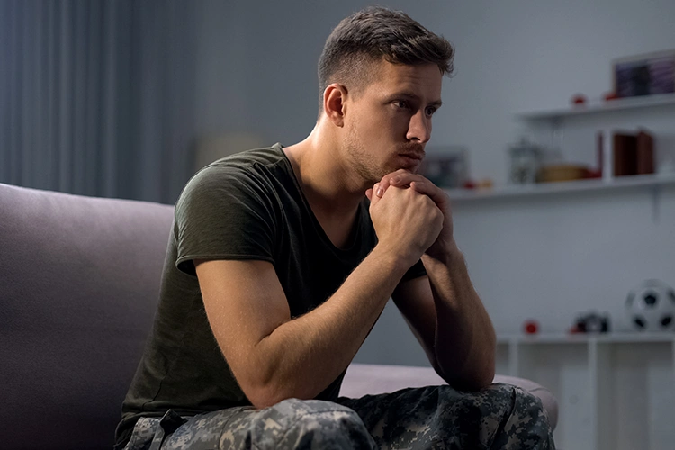 personne isolée plongée dans ses pensées, posture fermée et regard baissé